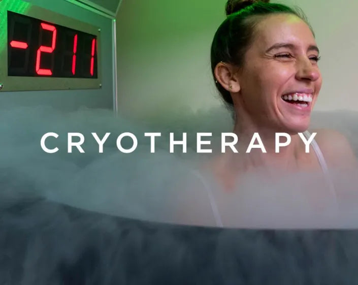Image of a smiling woman standing in a cryotherapy chamber with a temperature display showing -211 degrees
